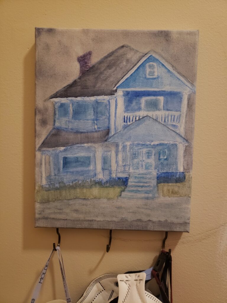 a watercolour on canvas of a brooding, slightly distorted, blue Victorian home floating on a gray lake with gray skies. there are three hooks on teh bottom of the canvas in a tarnished brass kind of colour that can hold keys or other items