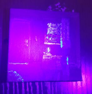 the same image as previously but tinted purple, in this some spots like the candle, window, and under the door glow to express where light might appear most strongly.