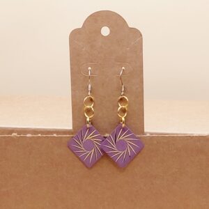 A product photo of a pair of purple square shapped earrings, with a spiral in the center, with gold toned rings.